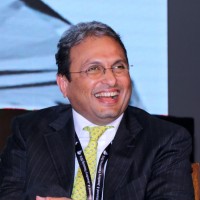 Headshot of Russell Mehta smiling during a panel discussion.