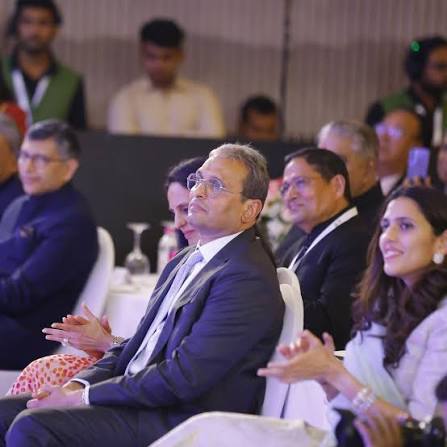 Russell Mehta seated among delegates in the front row at a gem and jewellery industry gathering.