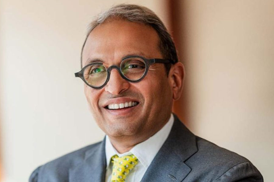 Russell Mehta, Managing Director of Rosy Blue (India), smiling in a grey suit and patterned yellow tie.