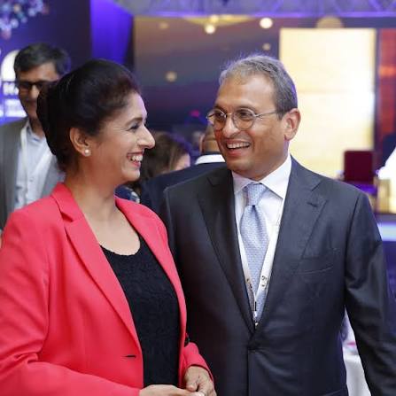 Russell Mehta in conversation with a colleague at an industry event, both smiling.